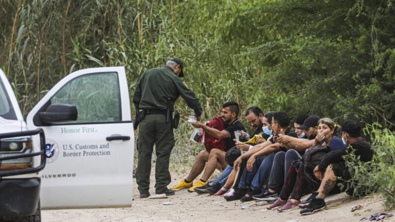 Un agente de la Patrulla Fronteriza detiene a un grupo de cubanos que acaba de cruzar el Río Grande desde México hacia Eagle Pass, Texas, el 19 de abril de 2022. (Charlotte Cuthbertson/The Epoch Times)
