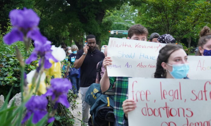 Connor (centro), un manifestante pro-aborto, marcha por el vecindario del juez Brett Kavanaugh y del juez John Roberts en Chevy Chase, Maryland, el 15 de mayo de 2022. (Jackson Elliott/The Epoch Times)