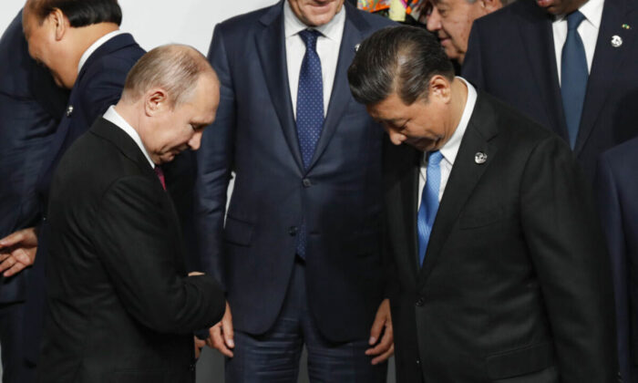 El presidente de Rusia, Vladimir Putin (izq.), y el líder chino Xi Jinping antes de una sesión de fotos familiares en la cumbre del G20 en Osaka, Japón, el 28 de junio de 2019. (Kim Kyung-Hoon/Pool/Getty Images)