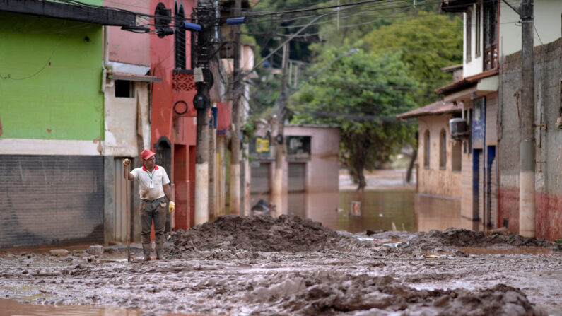 Un hombre es visto mientras limpia una calle después de una inundación en Raposos, estado de Mina Gerais, Brasil, el 11 de enero de 2022. (Douglas Magno / AFP vía Getty Images)