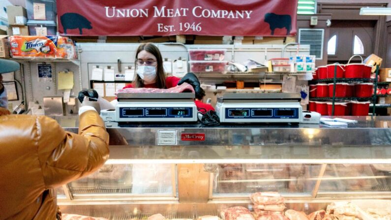 Un cliente paga por un corte de carne en Union Meat Company en Eastern Market en Washington, DC, el 8 de febrero de 2022. (STEFANI REYNOLDS/AFP via Getty Images)