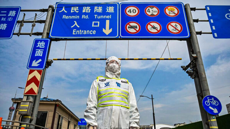 Un agente de tránsito, con equipo de protección, controla el acceso a un túnel cerca del distrito de Pudong de Shanghái durante el cierre del 28 de marzo de 2022. (Hector Retamal/AFP vía Getty Images)
