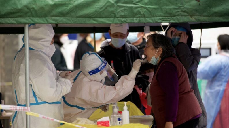 Un trabajador sanitario toma una muestra de un hisopo, que será analizado para detectar el coronavirus COVID-19, en un lugar de recogida de muestras en Beijing, China, el 27 de abril de 2022. (Noel Celis/AFP vía Getty Images)
