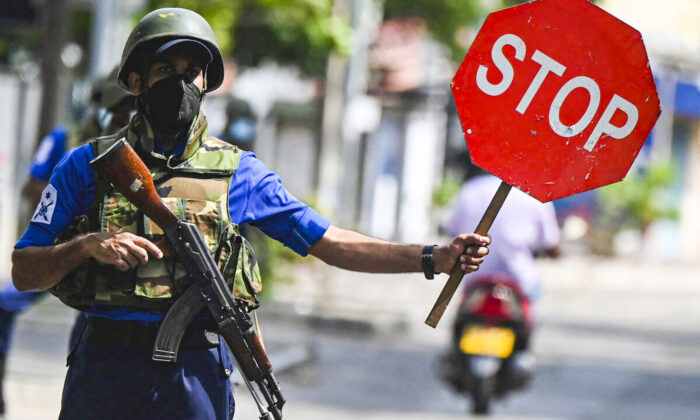 Un soldado de la marina sostiene una señal de alto en un puesto de control de carretera en Colombo (Sri Lanka) el 11 de mayo de 2022. (Ishara S. Kodikara/AFP vía Getty Images)