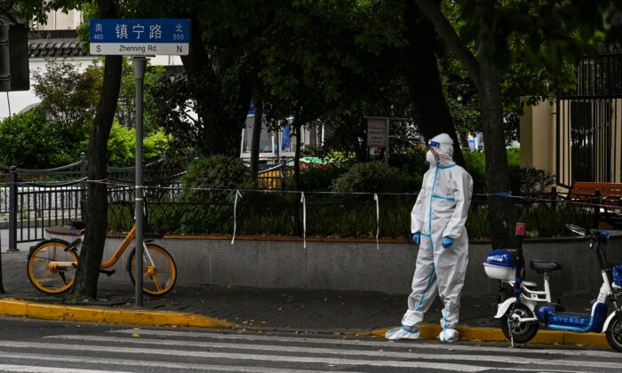 Esta foto, tomada el 10 de mayo de 2022, muestra a un trabajador parado en una calle durante un bloqueo por Covid-19 en el distrito de Jing'an, en Shanghai. (HÉCTOR RETAMAL/AFP vía Getty Images)
