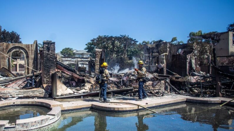 Bomberos luchan contra los focos de calor en una de las casas destruidas por el Coastal Fire en Laguna Niguel, California, el 12 de mayo de 2022. (Apu Gomes / AFP vía Getty Images)