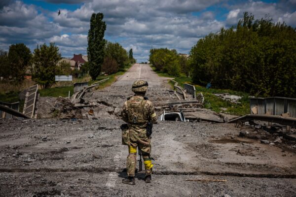 Un soldado de la unidad de las fuerzas especiales ucranianas, Kraken, observa la zona de un puente destruido en la carretera cerca del pueblo de Rus'ka Lozova, al norte de Kharkiv, el 16 de mayo de 2022. (Dimitar Dilkoff/AFP vía Getty Images)
