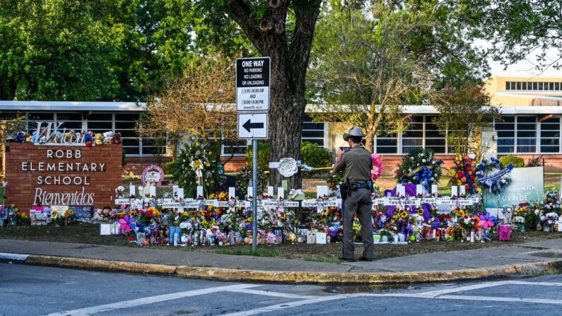 Un oficial de policía se encuentra cerca del monumento improvisado para las víctimas del tiroteo fuera de la Escuela Primaria Robb en Uvalde, Texas, el 28 de mayo de 2022. (CHANDAN KHANNA/AFP vía Getty Images)
