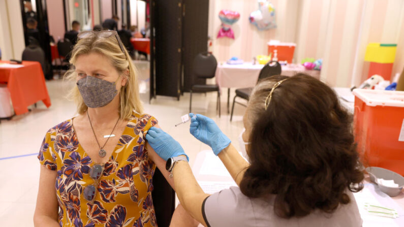 Una enfermera registrada administra una vacuna de refuerzo de COVID-19 a Diane Cowdrey (I) en una clínica de vacunación de COVID-19 el 06 de abril de 2022 en San Rafael, California. (Justin Sullivan/Getty Images)