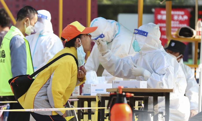 Un residente se somete a una prueba de COVID-19  un hisopo en un sitio de prueba de COVID-19, el 11 de mayo de 2022 en Beijing. (Lintao Zhang/Getty Images)