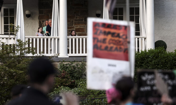 Los residentes observan cómo los manifestantes a favor del aborto marchan cerca de la casa del presidente de la Corte Suprema de Estados Unidos, John Roberts, en Chevy Chase, Maryland, el 11 de mayo de 2022. (Kevin Dietsch/Getty Images)