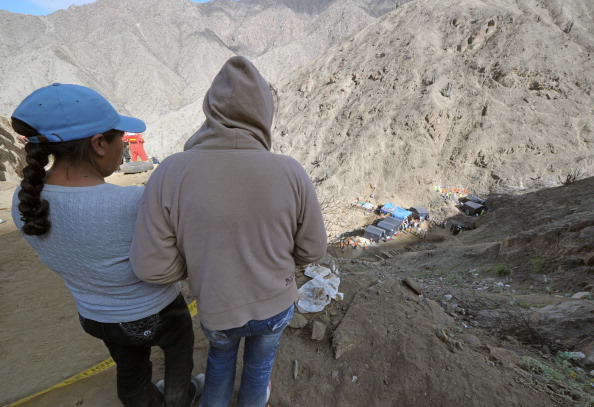 Dos personas miran hacia abajo en la mina de cobre Cabeza de Negro, una mina a 1300 metros sobre el nivel del mar en los Andes al este de Ica, 325 km. al sur de Lima, el 8 de abril de 2012. (CRIS BOURONCLE/AFP a través de Getty Images)