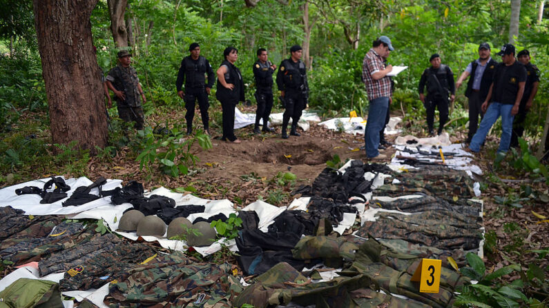 Agentes del Ministerio Público, miembros de la Policía Nacional Civil y soldados revisan uniformes de estilo militar y armas incautadas a presuntos narcotraficantes en varias redadas en el barrio de Las Flores, departamento de Zacapa, a 150 kms al norte de Ciudad de Guatemala, el 28 de mayo de 2012.  (STR/AFP/GettyImages)