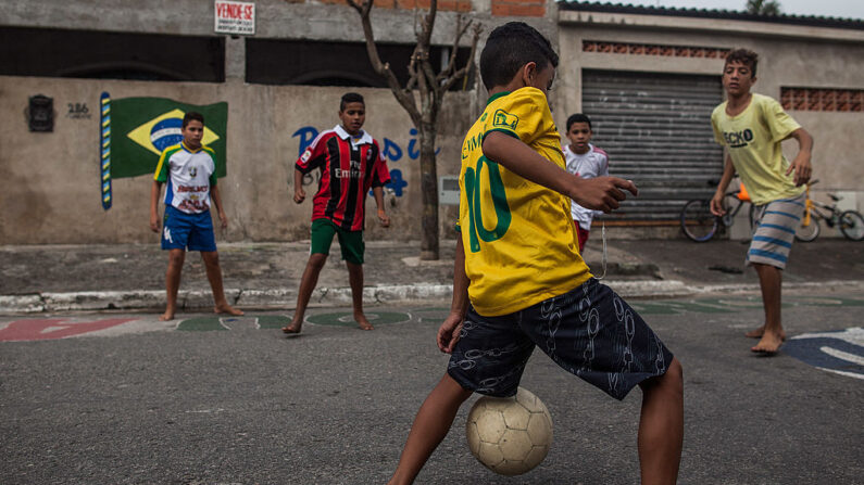 Niños juegan al fútbol en las calles del barrio Garden Gloria el 17 de junio de 2014 en Praia Grande, Brasil. (Victor Moriyama/Getty Images)