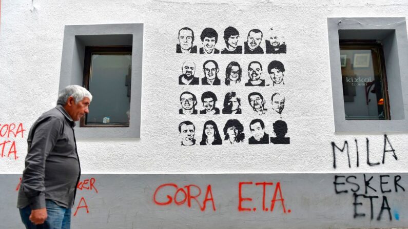 Un hombre pasa por delante de una pintada que muestra retratos de presos del grupo separatista vasco ETA y que dice "Larga vida a ETA, muchas gracias" en el pueblo vasco español de Hernani el 5 de mayo de 2018. (Ander Gillenea/AFP vía Getty Images)