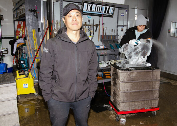Shintaro Okamoto (izquierda) en su estudio de escultura en hielo, mientras Christian López trabaja en una pieza para un cliente. (Dave Paone/The Epoch Times)