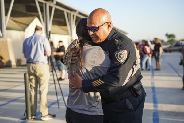 El jefe de policía del distrito escolar de Uvalde, Pete Arredondo, abraza a un estudiante de la escuela en una noche de oración comunitaria celebrada el día después de un tiroteo masivo en la Escuela Primaria Robb, en el que murieron 19 niños y 2 adultos, en Uvalde, Texas, el 25 de mayo de 2022. (Charlotte Cuthbertson/The Epoch Times)