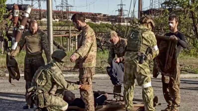 Captura de pantalla a un video facilitado por el ministerio de Defesa ruso que muestra varios soldados rusos requisando a militares ucranianos tras salir de la acería de Azovstal, en Mariúpol. (EFE/EPA/FOLLETO DEL SERVICIO DE PRENSA DEL MINISTERIO DE DEFENSA DE RUSIA)