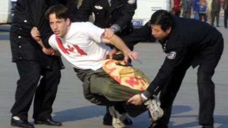 Agentes de la policía china se llevan a un practicante canadiense de Falun Gong tras participar en una protesta pacífica en la plaza de Tiananmen en noviembre de 2001. (Minghui.org)