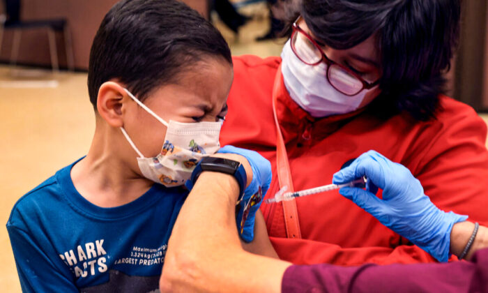 El estudiante de primer grado, Leonel Campos de 6 años, recibe una vacuna contra el COVID-19 en el Instituto Arturo Velasquez en Chicago, Illinois, el 12 de noviembre de 2021. (Scott Olson/Getty Images)