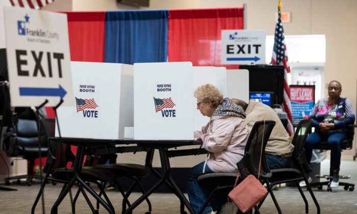 Los votantes usan una casilla de votación con boletas de papel opcionales cuando emiten sus boletas temprano para las Elecciones Primarias del 3 de mayo en el lugar de votación de la Junta Electoral del Condado de Franklin, el 26 de abril de 2022, en Columbus, Ohio. (Drew Angerer/Getty Images)