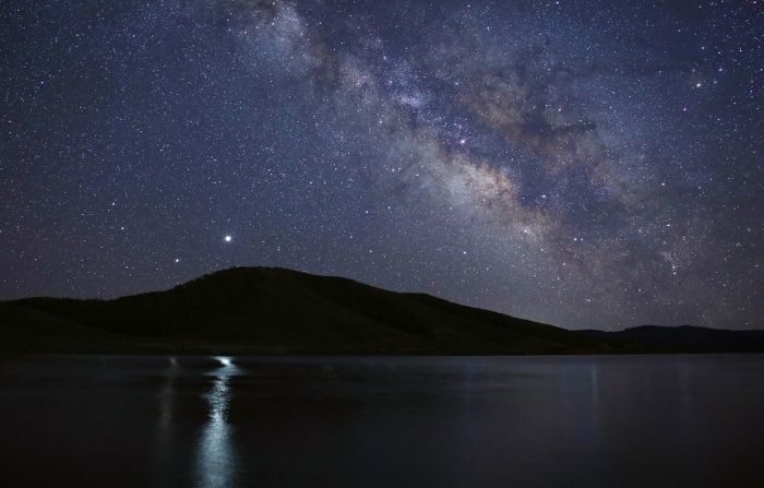 Saturno (I) y Júpiter (D) proyectan sus reflejos en las aguas de Strawberry Reservoir, Utah, en junio de 2020. (Crédito: NASA/Bill Dunford)