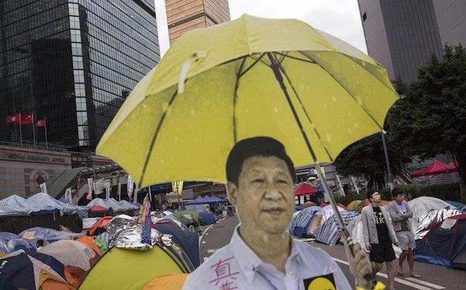 Un recorte de cartón del presidente chino Xi Jinping sosteniendo un paraguas amarillo, el símbolo de un movimiento prodemocracia, se ve fuera de una tienda de campaña utilizada por los manifestantes en el lugar de la protesta de Admiralty el 13 de noviembre de 2014, en Hong Kong. El Tribunal Superior de Hong Kong autorizó a la policía a detener a los que obstruyeran a los agentes judiciales en tres órdenes provisionales. (Foto de Kevin Frayer/Getty Images)