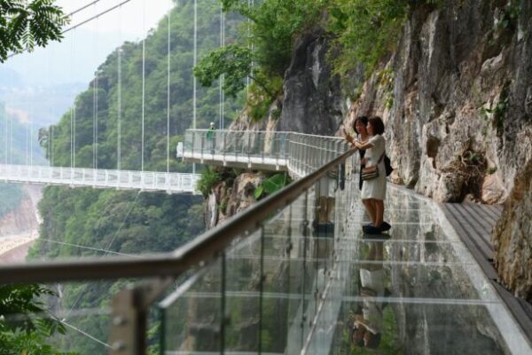 Visitantes parados en la la pasarela del puente de cristal de Bach Long en el distrito de Moc Chau en la provincia de Son La, Vietnam, el 29 de abril del 2022. (Nhac Nguyen/AFP vía Getty Images)