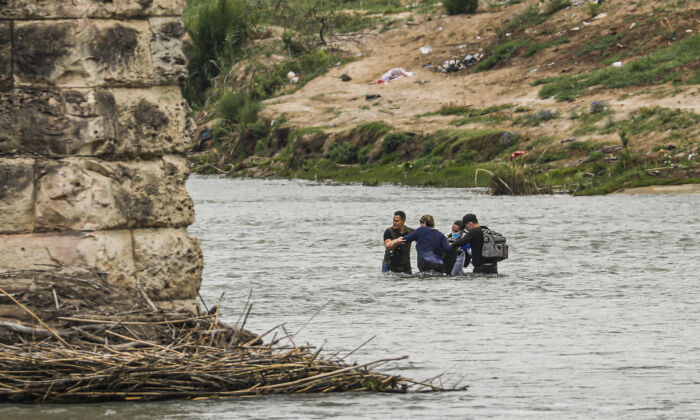 Un grupo de cubanos vadea el Río Grande desde México hacia Estados Unidos en Eagle Pass, Texas, el 19 de abril de 2022. (Charlotte Cuthbertson/The Epoch Times)