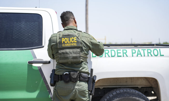 Un agente de la Patrulla Fronteriza completa el papeleo mientras detiene a un gran grupo de inmigrantes ilegales cerca de Eagle Pass, Texas, el 20 de mayo de 2022. (Charlotte Cuthbertson/The Epoch Times)