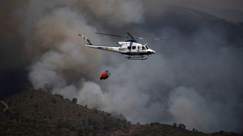 Un helicóptero que participa en la contención del fuego en la Sierra Bermeja de Málaga (España) es fotografiado desde Benahavís el 9 de junio de 2022. (Jorge Guerrero/AFP vía Getty Images)