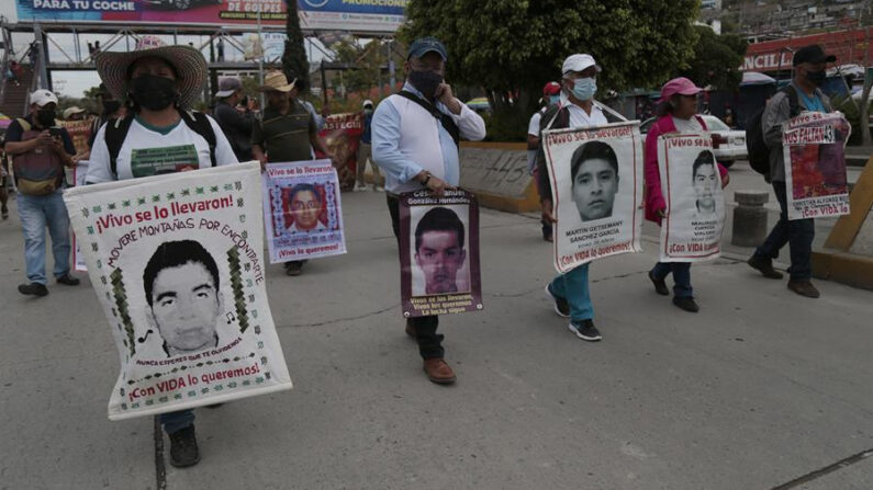 Varias personas, entre ellos familiares y amigos de los 43 estudiantes de Ayotzinapa desaparecidos desde 2014 en el estado de Guerrero, protestan con imágenes de los jóvenes el 6 de junio de 2022, en Chilpancingo (México). EFE/ José Luis De La Cruz