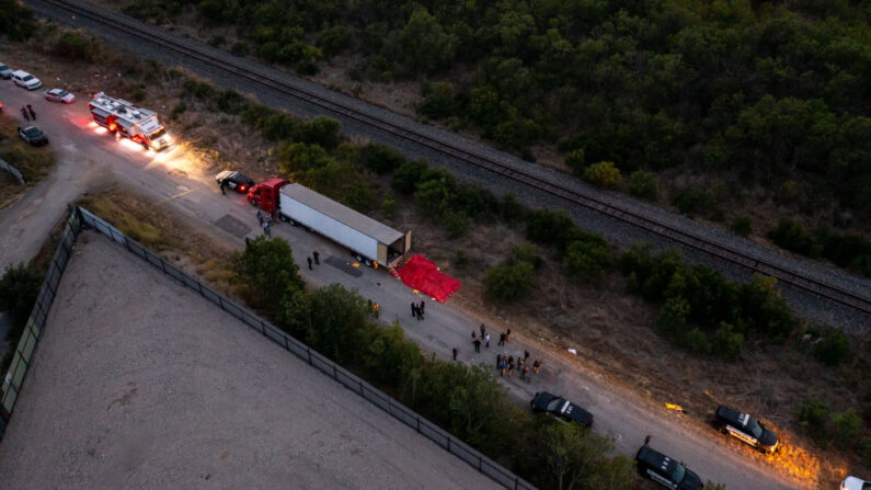En esta vista aérea, miembros de las fuerzas del orden investigan las muertes en un tráiler, el 27 de junio de 2022, en San Antonio, Texas. (Jordan Vonderhaar/Getty Images)