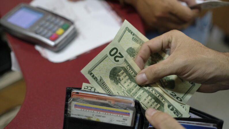 Un cliente paga con dólares estadounidenses en una panadería el 26 de junio de 2019 en Caracas, Venezuela. (Matias Delacroix/Getty Images)
