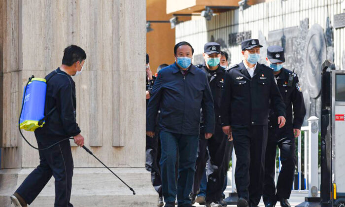 Policías y funcionarios salen de un instituto en Beijing, China, el 27 de abril de 2020. (Greg Baker/AFP vía Getty Images)