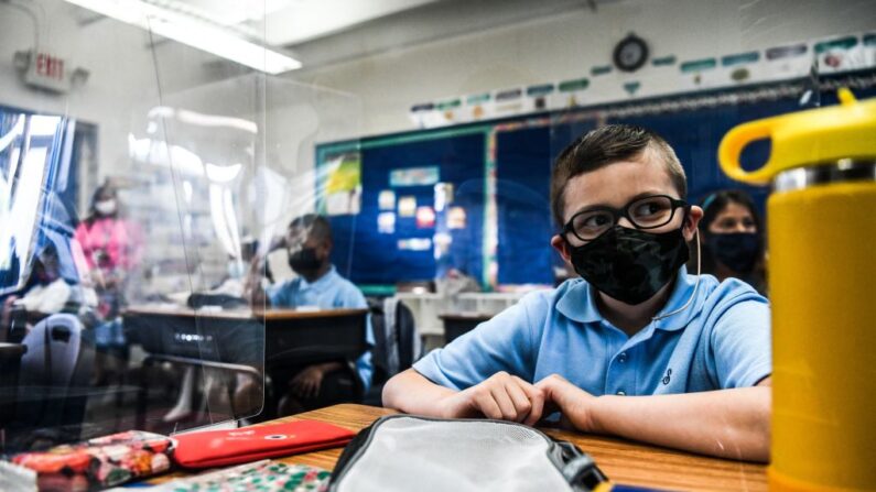 Los estudiantes llevan mascarillas mientras asisten a su primer día en la escuela después de las vacaciones de verano en la Escuela Católica de San Lorenzo en el norte de Miami, el 18 de agosto de 2021. (CHANDAN KHANNA/AFP vía Getty Images)