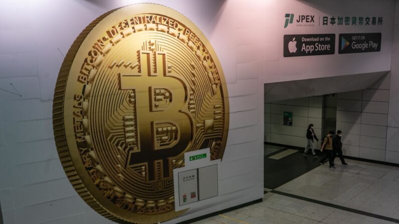 Los peatones pasan por delante de un anuncio que muestra un token de la criptomoneda Bitcoin, el 15 de febrero de 2022, en Hong Kong, China. (Anthony Kwan/Getty Images)