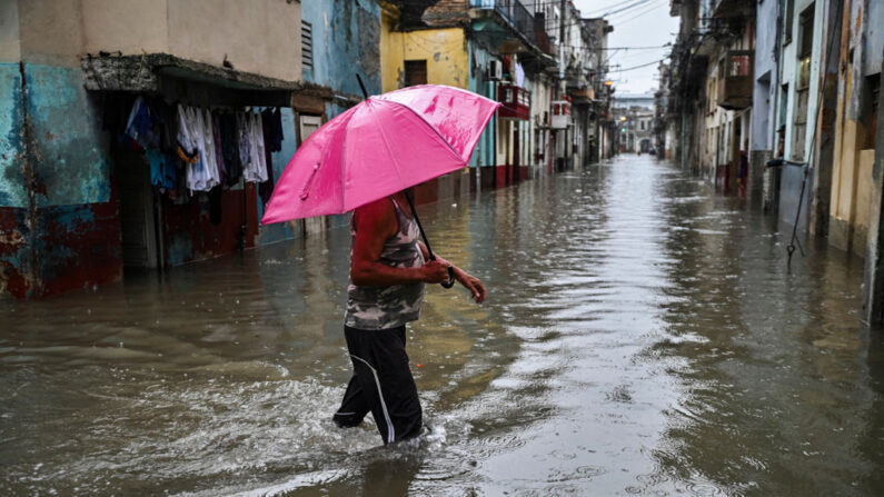 Un hombre con un paraguas vadea una calle inundada de La Habana (Cuba), el 3 de junio de 2022. (Yamil Lage/AFP vía Getty Images)