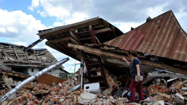 Una mujer se encuentra sobre los escombros de su casa destruida en el pueblo de Nalyvaikivka, en la región de Kiev (Ucrania), el 15 de junio de 2022, cuando la guerra entre Rusia y Ucrania entra en su 112º día. (Sergei Chuzavkov/AFP vía Getty Images)