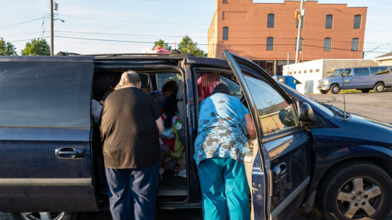 En la imagen, una familia caminan de vuelta a su coche donde han estado viviendo en su caravana durante el último año mientras buscan un apartamento asequible. (Spencer Platt/Getty Images)