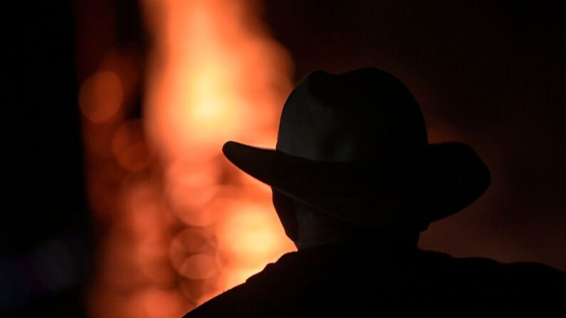 Un hombre observa las llamas de una hoguera de 7 metros realizada por la comunidad quilombola de Mato do Ticao, en Jaboticatubas, estado de Minas Gerais, Brasil, en la noche del 23 al 24 de junio de 2022. (DOUGLAS MAGNO/AFP vía Getty Images)