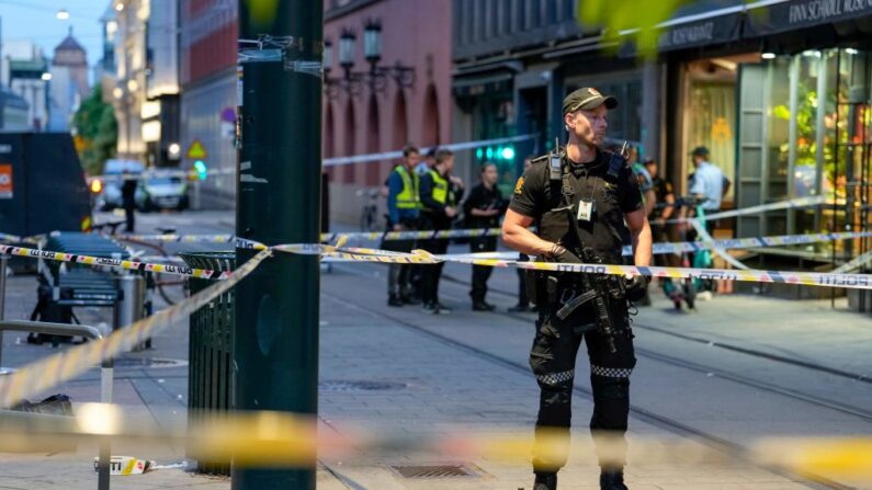 Un agente de policía noruego monta guardia en las calles del centro de Oslo entre las cintas de seguridad, el 25 de junio de 2022, después de que se produjeran disparos en el exterior del pub London, que causaron la muerte de dos personas. (JAVAD PARSA/NTB/AFP via Getty Images)