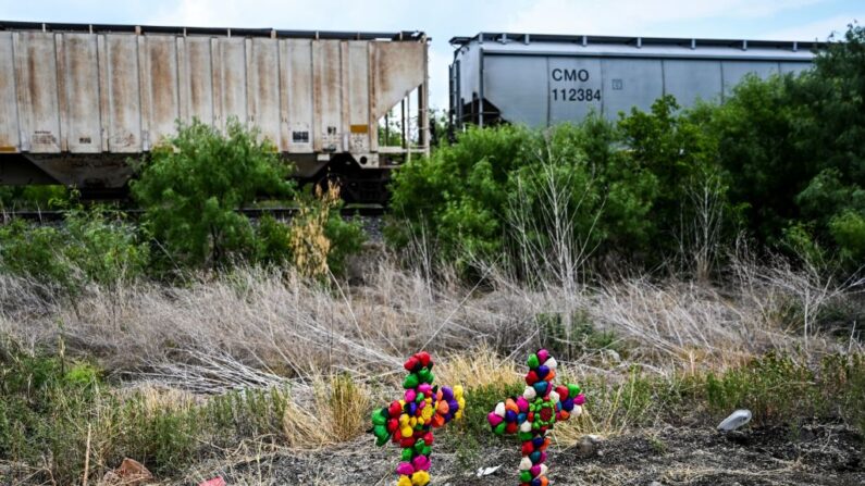 Cruz y velas en el lugar donde se descubrió un camión con migrantes dentro, en las afueras de San Antonio, Texas, el 28 de junio de 2022. (CHANDAN KHANNA/AFP vía Getty Images)