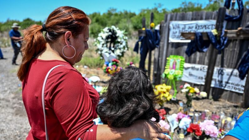 Un grupo de personas visita un monumento improvisado en el lugar donde se descubrió un remolque con inmigrantes dentro, en las afueras de San Antonio, Texas (EE.UU.), el 29 de junio de 2022. (Chandan Khanna/AFP vía Getty Images)