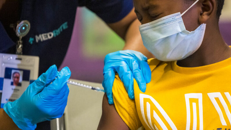 Tse Cowan, de 8 años de edad, hace una mueca de dolor mientras se le administra la vacuna contra el COVID-19 en un sitio de vacunación emergente en P.S. 19 el 08 de noviembre de 2021 en el Lower East Side en la ciudad de Nueva York(Michael M. Santiago/Getty Images)

