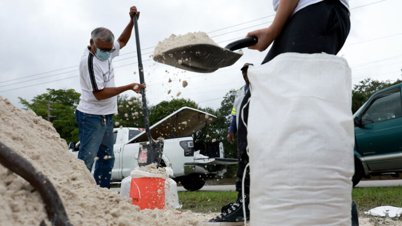 La gente llena sacos de arena mientras preparan sus casas para la llegada esperada de una tormenta tropical el 03 de junio de 2022 en Pembroke Pines, Florida. (Joe Raedle/Getty Images)