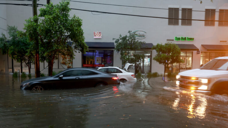 Coches sentados en una calle inundada causada por un diluvio de lluvia de una tormenta tropical que pasa por la zona el 04 de junio de 2022 en Miami, Florida (EE.UU.). (Joe Raedle/Getty Images)