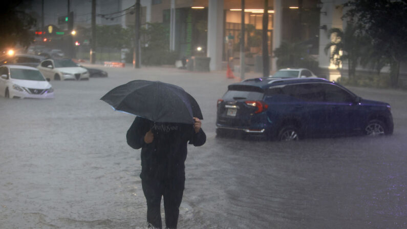 Un peatón camina a través de una calle inundada causada por un diluvio de lluvia de una tormenta tropical que pasa por la zona el 04 de junio de 2022 en Miami, Florida. (Joe Raedle/Getty Images)