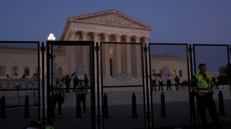 Agentes de la ley permanecen dentro del perímetro de seguridad del edificio de la Corte Suprema de Estados Unidos mientras se producen protestas en reacción al anuncio del fallo de Dobbs vs Jackson Women's Health Organization el 24 de junio de 2022 en Washington, DC. (Anna Moneymaker/Getty Images)
