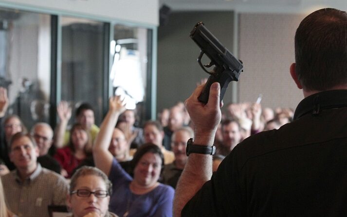 El instructor de armas de fuego Clark Aposhian sostiene una pistola en alto mientras imparte una clase de formación sobre armas ocultas a 200 maestros de Utah en West Valley City, Utah, el 27 de diciembre de 2012. (George Frey/Getty Images)

